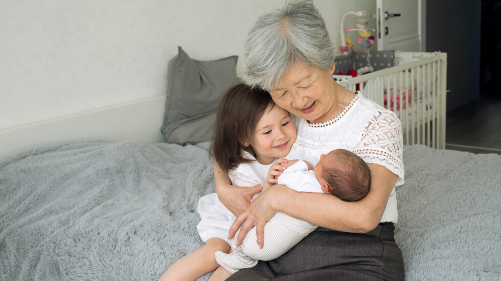 A great grandmother visits with her two great granddaughters, one a newborn baby.