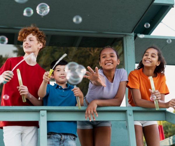 Friends spending some quality time together outdoors blowing bubbles